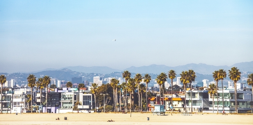 Seafront buildings and sandy beach on a sunny day in California.