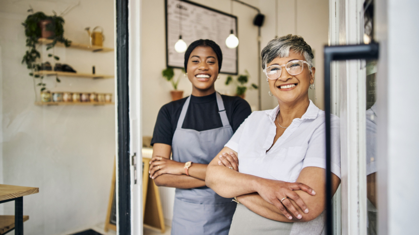 Coffee shop, senior woman manager portrait with barista feeling happy about shop success. Female server, waitress and small business owner together proud of cafe and bakery growth with a smile