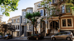 Cars parked near mansions in San Francisco residential district in sunlight