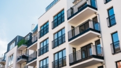 A white apartment building façade with balconies and windows.