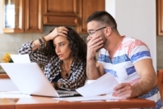 Young woman and man sitting at home and making home finances, with casual clothes