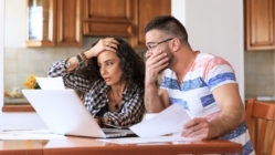 Young woman and man sitting at home and making home finances, with casual clothes