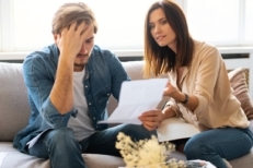 Photo of young couple analyzing their finances with documents