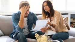 Photo of young couple analyzing their finances with documents