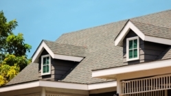 Roof shingles with house on top of the house. dark asphalt tiles on the roof background on afternoon time. dark asphalt tiles on the roof background