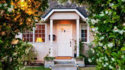 A small house with a white picket fence in front of it