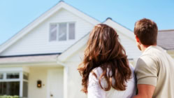 Rear view of a couple standing in front of their house