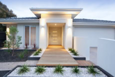 A modern home with a wood slat walkway leading to the front door