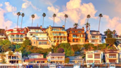 A row of colorful houses in California line the shore of the Pacific Ocean.