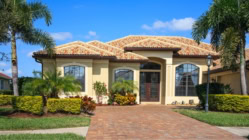 A nice home in Florida with palm trees in front of it.