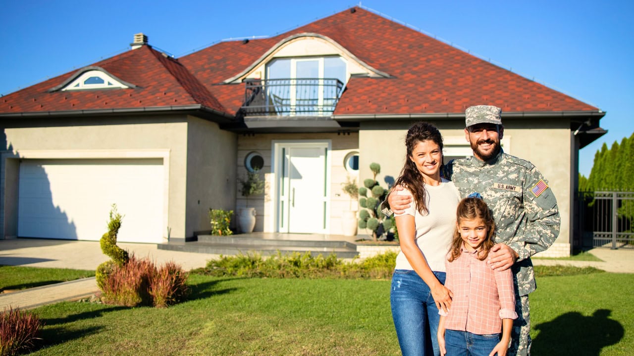 A military family standing in front of their new home.