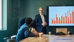 Business professionals are sitting around a conference table having a meeting about 2nd mortgages for non-owner-occupied (investment) properties.