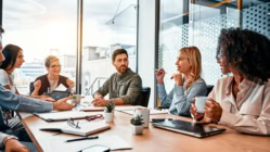 Multinational professionals business people discussing daily topics by table in modern office. Business meeting.