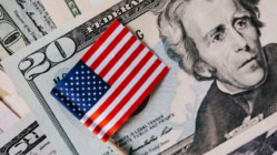 American flag on US dollar bills symbolizing the United States economy, money, and financial markets