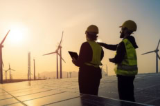 Engineers inspecting solar panels and wind turbines at a renewable energy farm during sunset, symbolizing clean energy and sustainability"