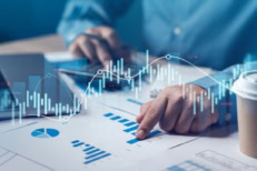 Analyst reviewing economic charts and graphs with a rising and falling data line overlay, representing uncertainty in financial data during a government shutdown.