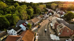 A curving road leads alongside the historic tree lined residential district