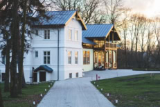 Luxury country home with detached guest house and long driveway, showcasing residential real estate, property value, and upscale homeownership.