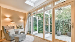 A picture of a living room that has a big window and door out to the garden