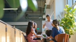 Business team meeting in a modern office with manager leading discussion, representing collaboration, leadership, and workplace productivity.
