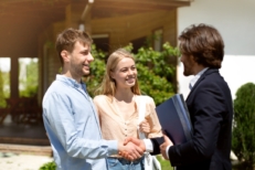 A couple talking with their agent, shaking hands
