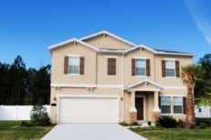 Picture of a House with trees and green grass. House has a garage